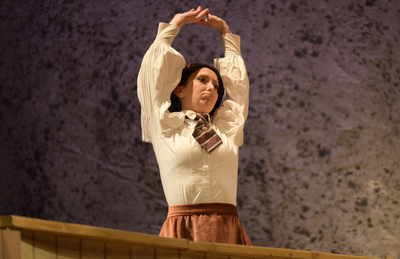 a woman stretches her arms above her head, while doing lip trills
